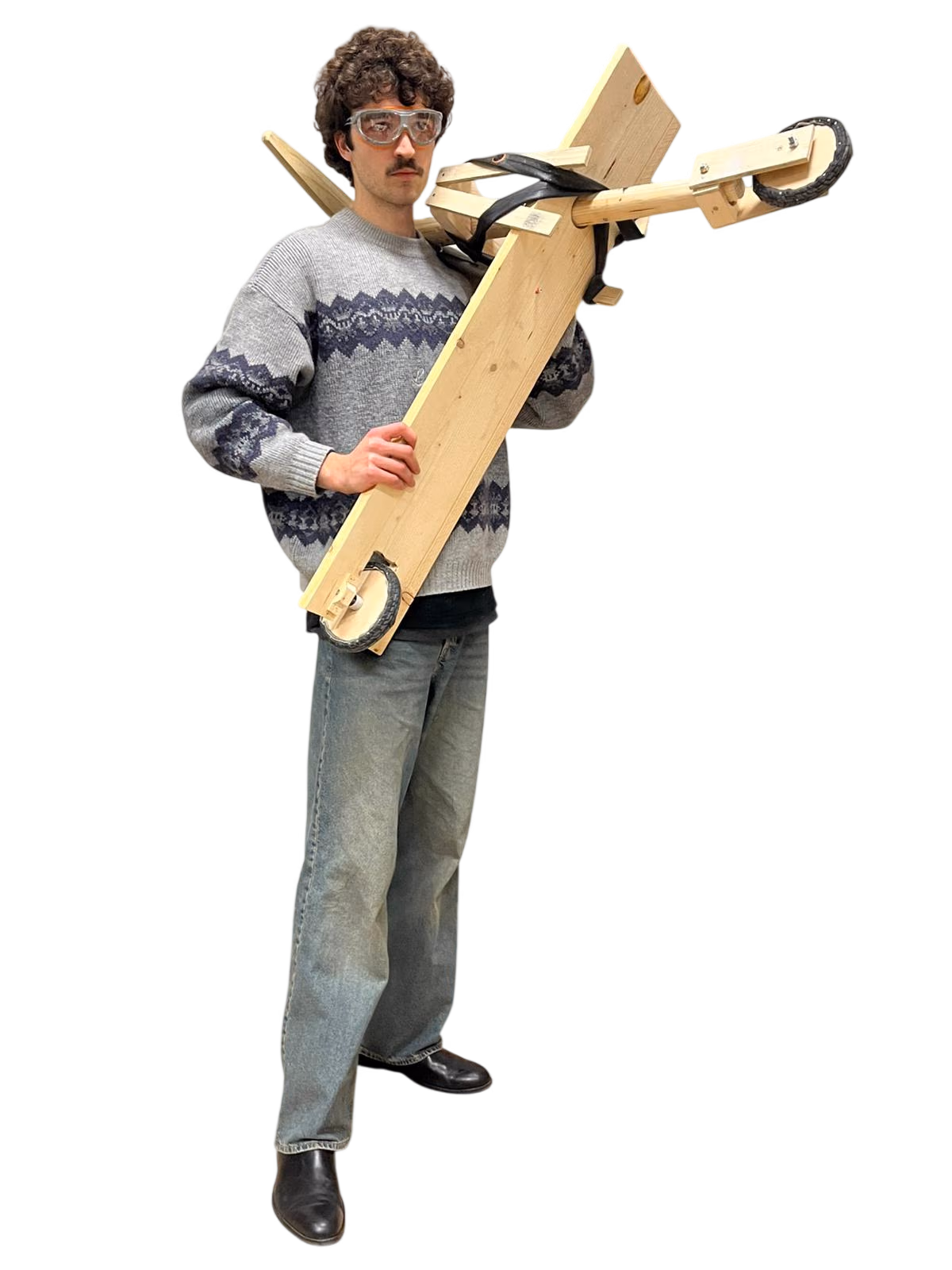 Alessio Fontanelli carrying the wooden mini chukudu on his shoulder, wearing safety goggles