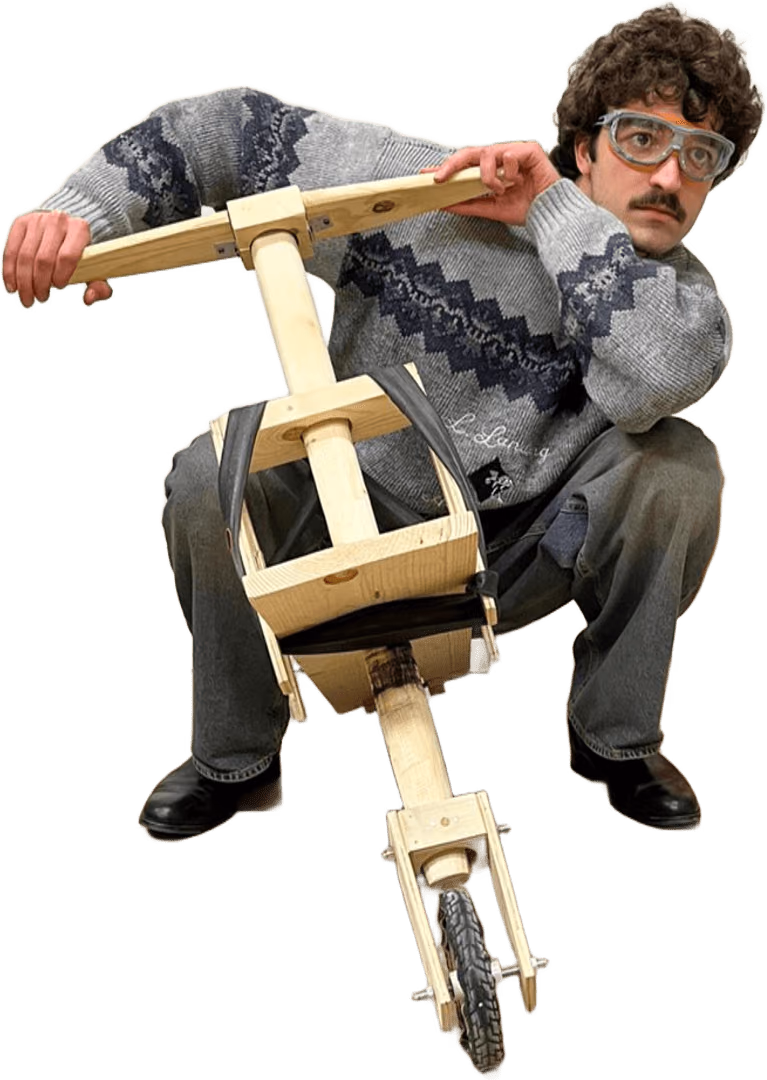 Alessio Fontanelli crouching on the wooden mini chukudu, holding the handlebar