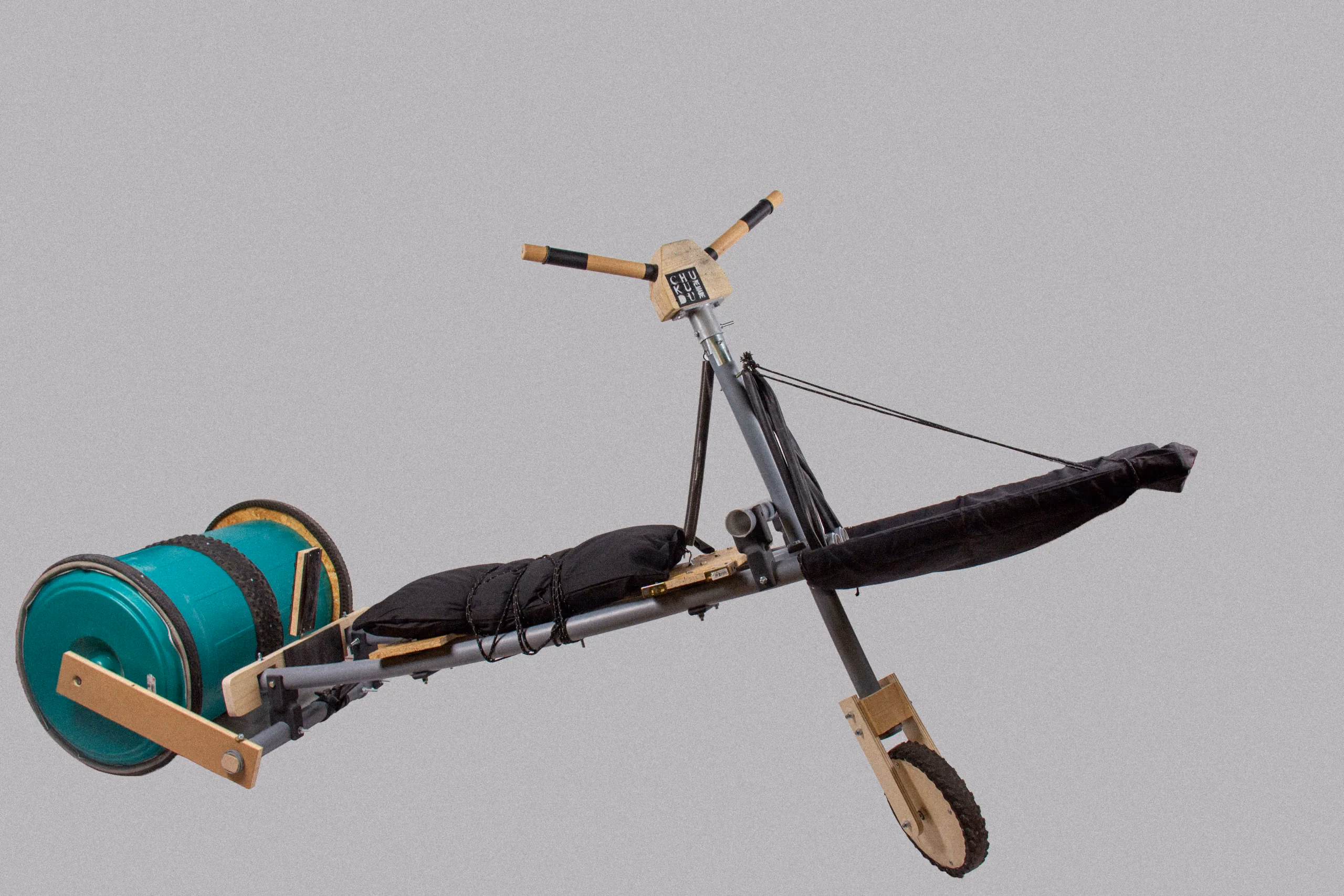 The full-size prototype in the studio: tube frame, turquoise drum wheel, wooden handlebar