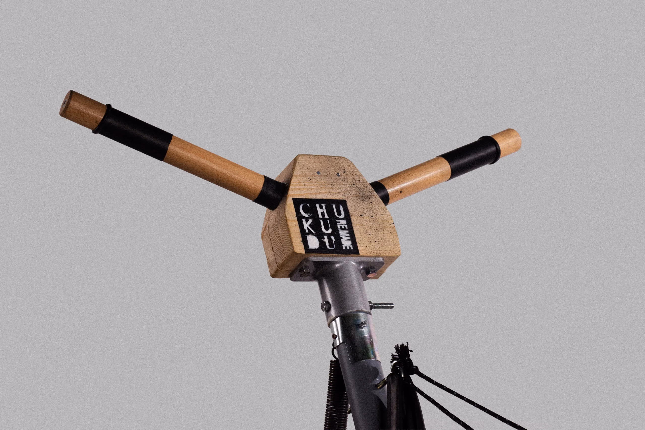 The wooden handlebar of the prototype, branded with the project mark